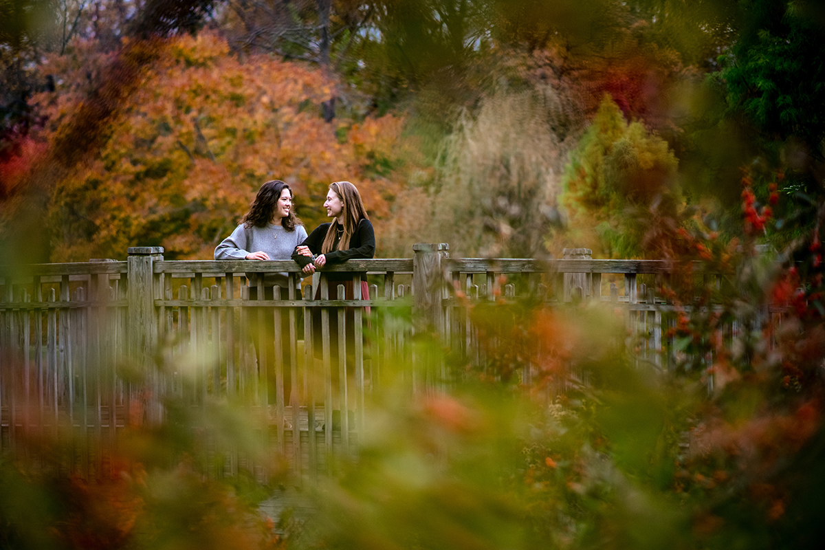 Two brides posing during their fall color engagement session at the Brookside Gardens in Maryland by Potok's World Photography